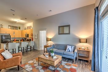 A living room with a grey couch, a brown armchair, and a coffee table